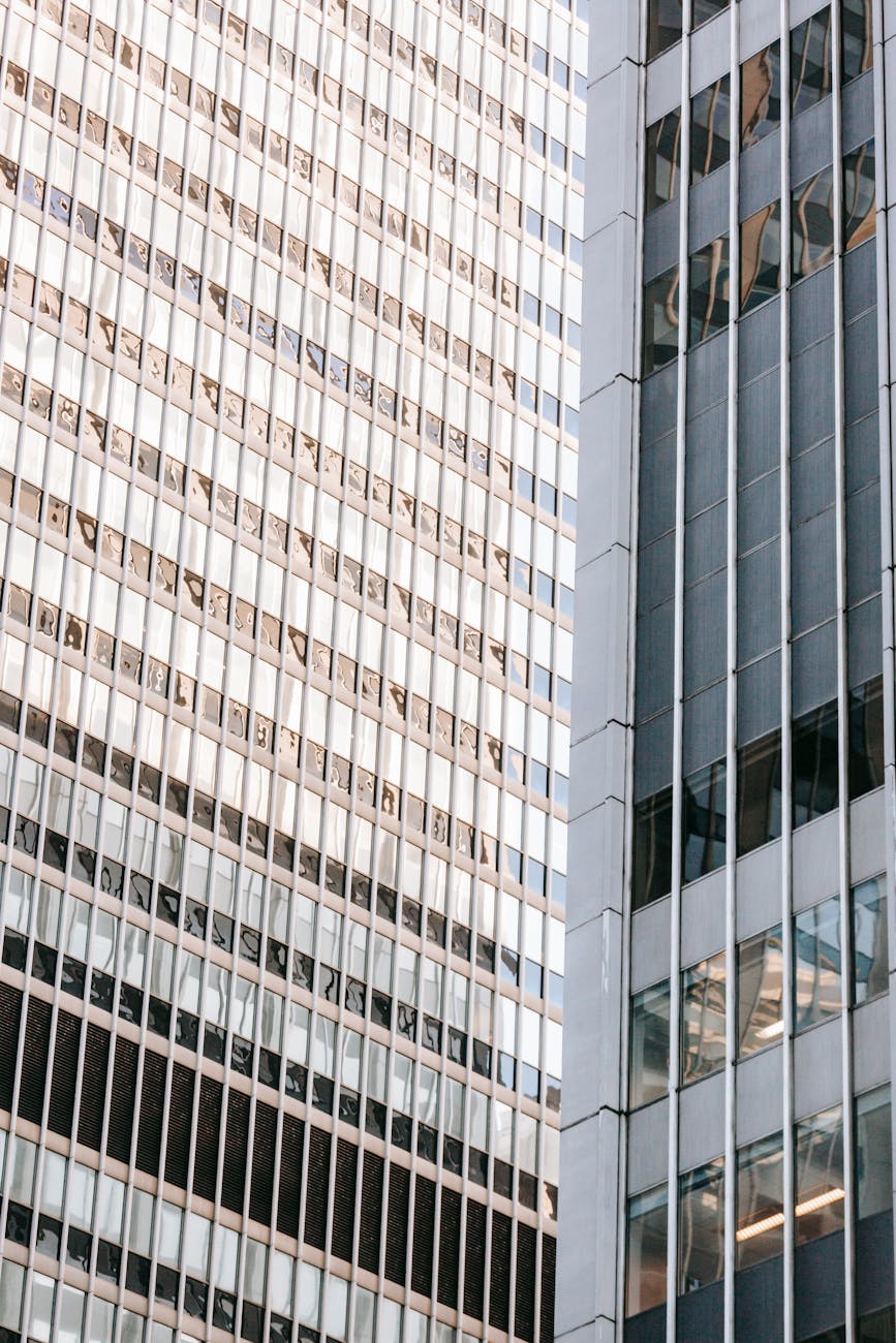 Low angle of contemporary multistory building facades with symmetrical rows of beams on walls in town