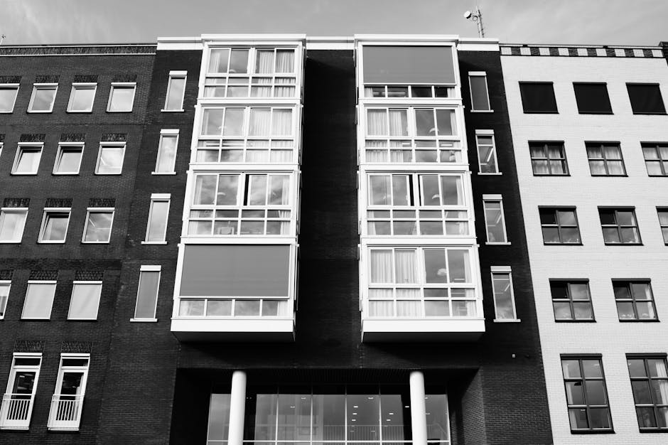 Black and white view of a modern building facade with tall windows.